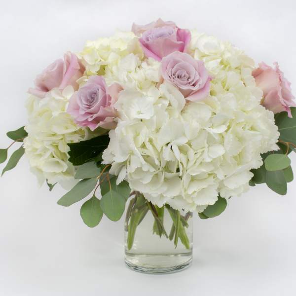 Pink roses and white hydrangeas in a clear glass vase