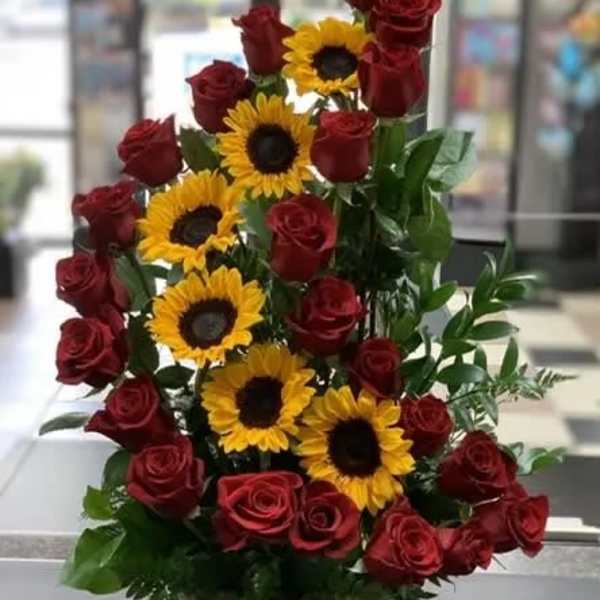 Basket arrangement of red roses and yellow sunflowers