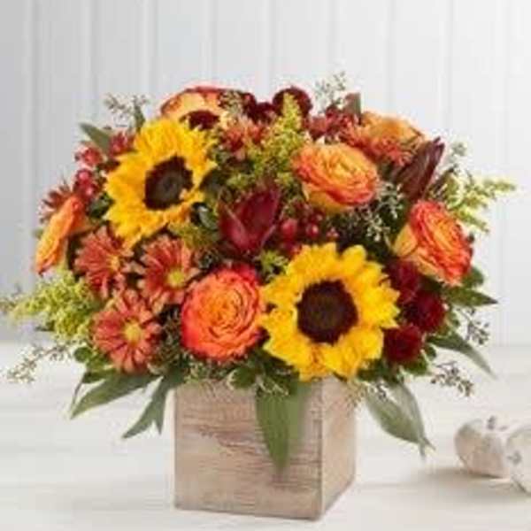 Mixed bouquet of sunflowers and orange flowers in a square box
