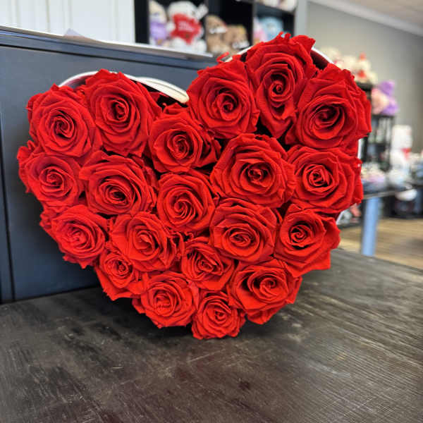 Heart-shaped arrangement of red roses in a black box
