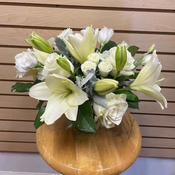 White lilies and roses arranged in a low bouquet
