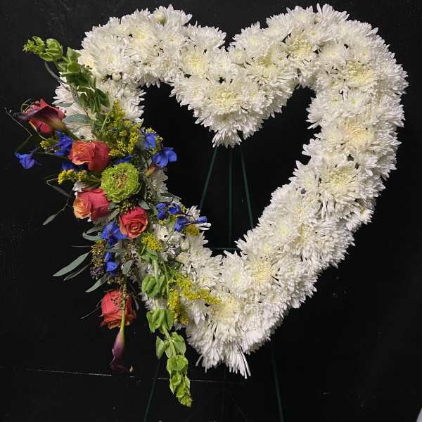 Heart-shaped floral tribute with white chrysanthemums and colorful roses