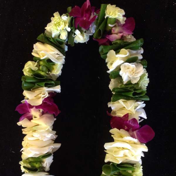 Flower lei with white, yellow, and purple blooms on a black background