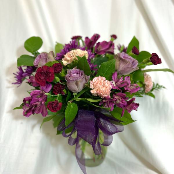 Bouquet of purple and pink flowers with a purple ribbon