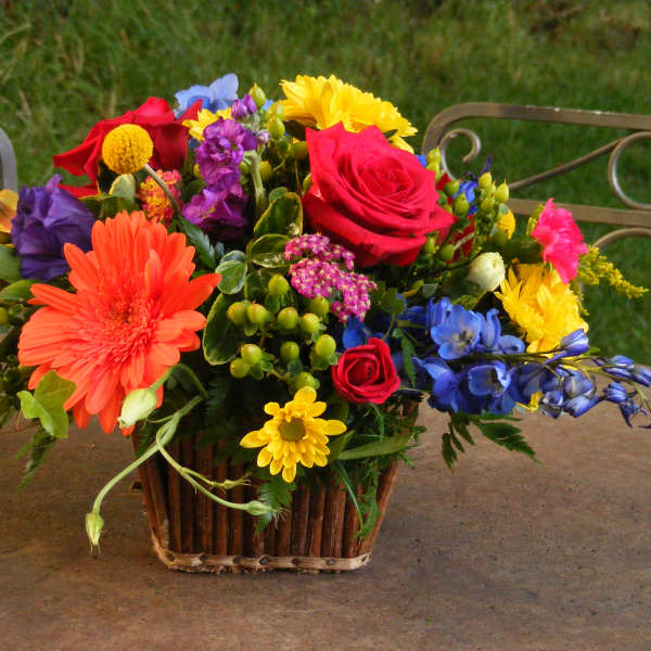 Colorful mixed flower arrangement in a basket on a table