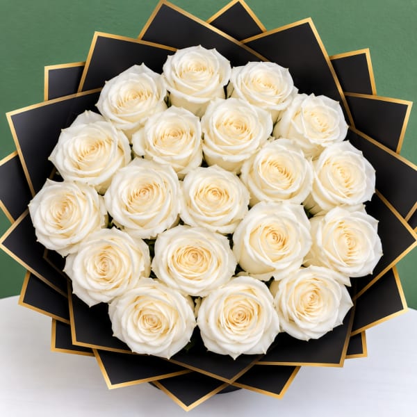 Bouquet of white roses wrapped in black paper with gold trim