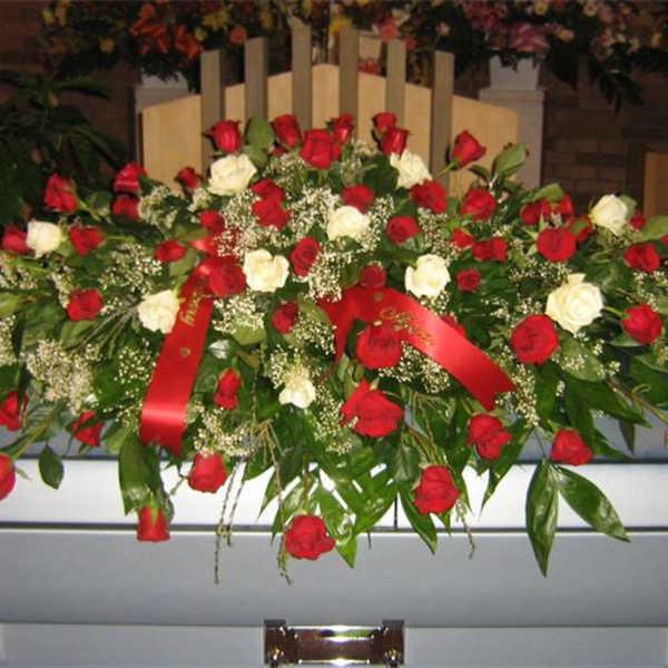 Red and white rose casket spray with ribbon