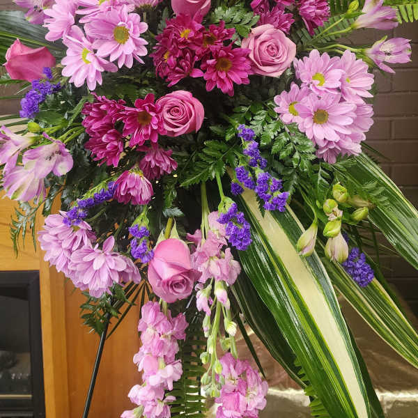 Large pink and purple floral standing spray with roses and daisies