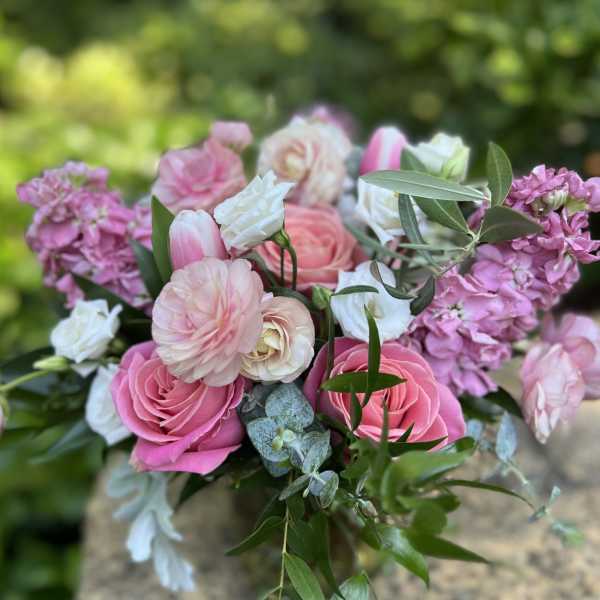 Pink and white bouquet of roses and ranunculus with greenery