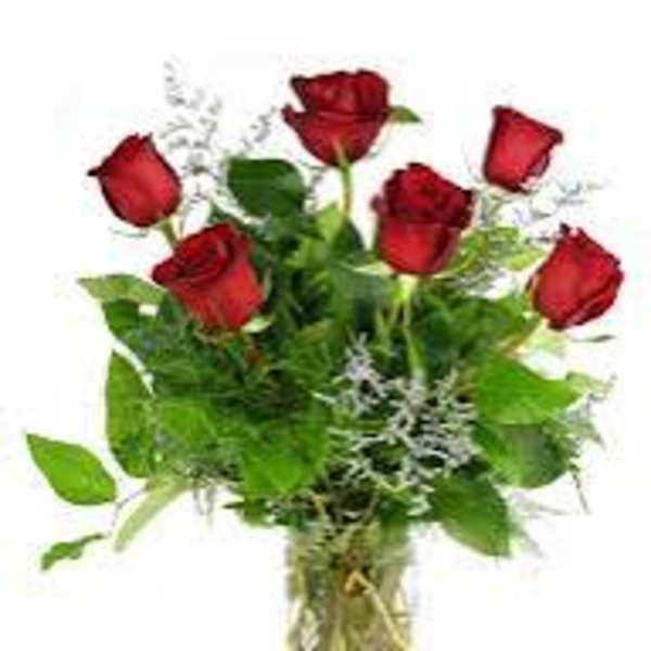 Bouquet of red roses with greenery in a clear vase
