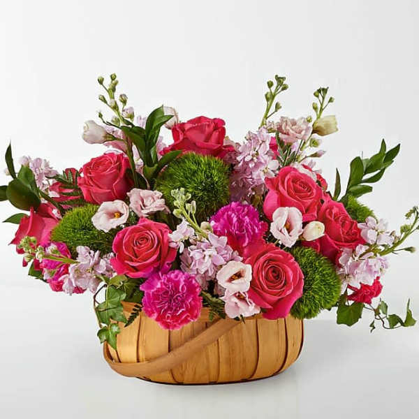 Pink roses and carnations in a woven basket