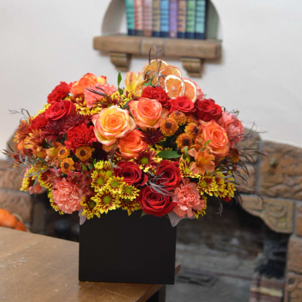 Autumn bouquet of red and orange flowers in a black box