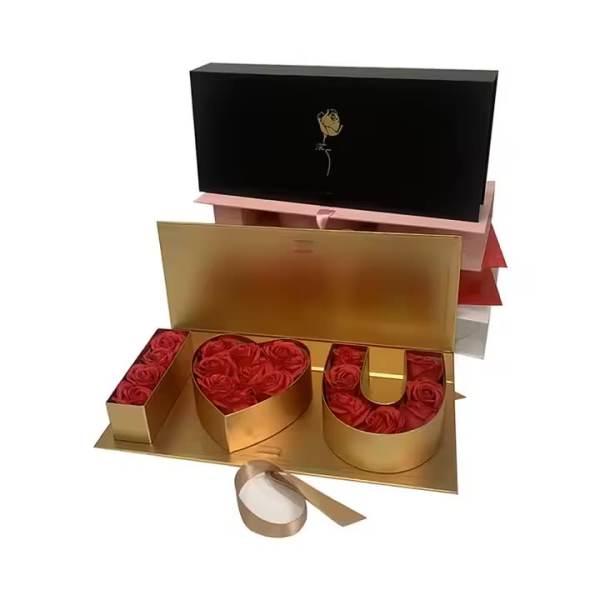 Gold gift box with red roses arranged as I heart U