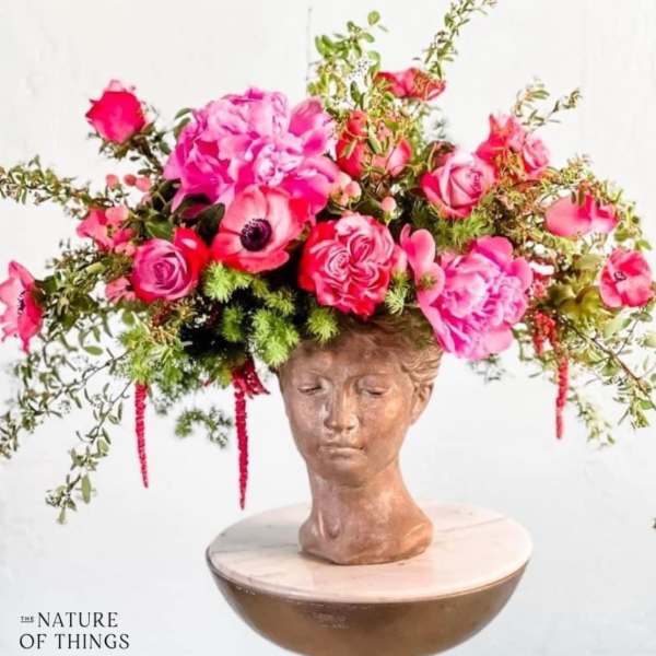 Pink floral crown on a sculpted head bust