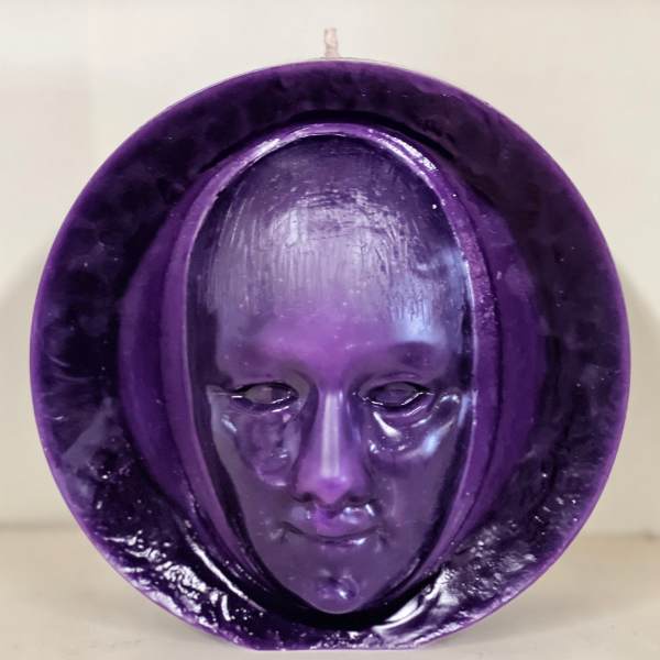 Purple decorative mask sculpture with a face in the center