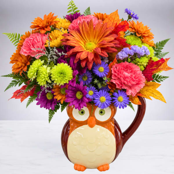 Colorful flower arrangement in an owl-shaped ceramic mug