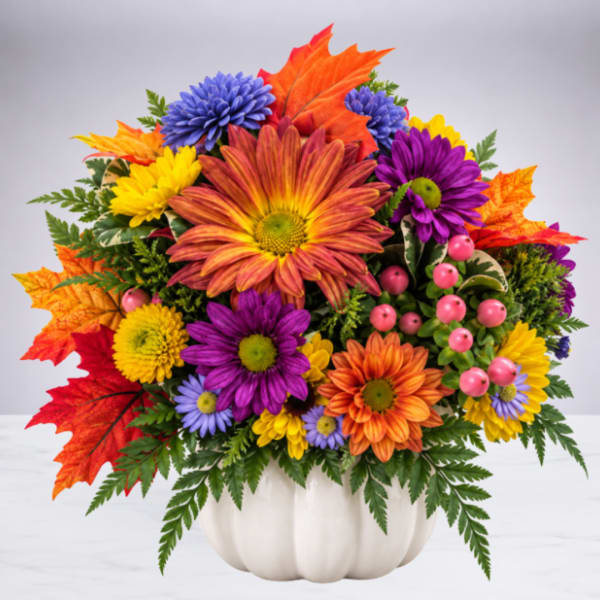 Colorful autumn bouquet in a white pumpkin-shaped container