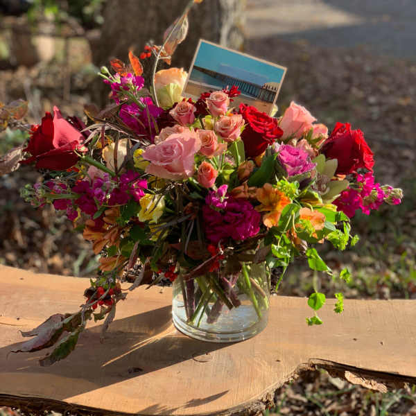 Mixed bouquet of pink and red roses in a clear glass vase