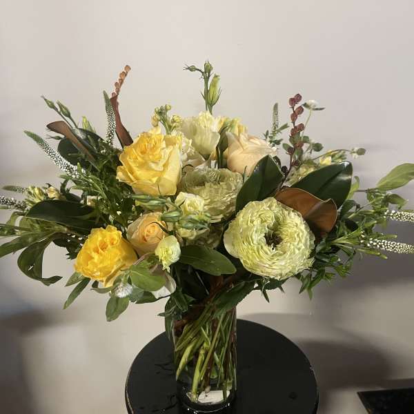 Yellow and cream rose bouquet in a clear glass vase