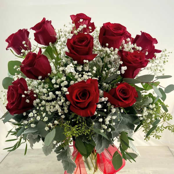 Bouquet of red roses with baby's breath in a glass vase