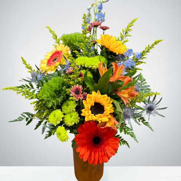Colorful mixed flower arrangement in a brown vase