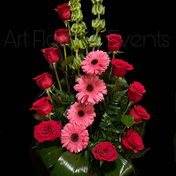 Red roses and pink gerbera daisies in a tall arrangement