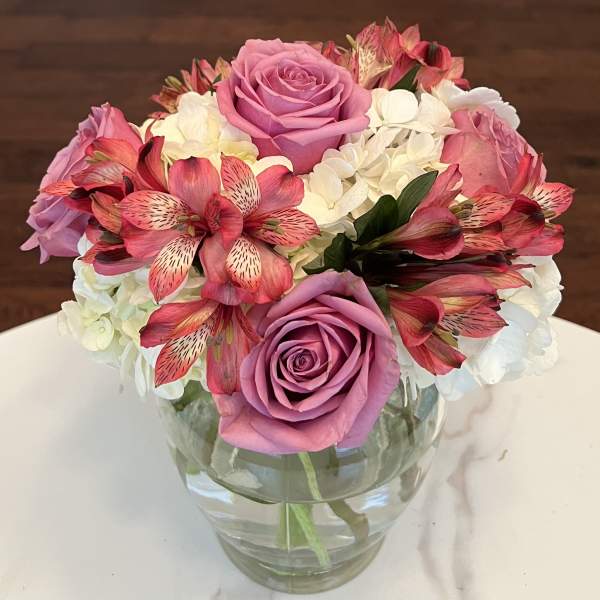 Pink roses and white hydrangeas in a clear glass vase
