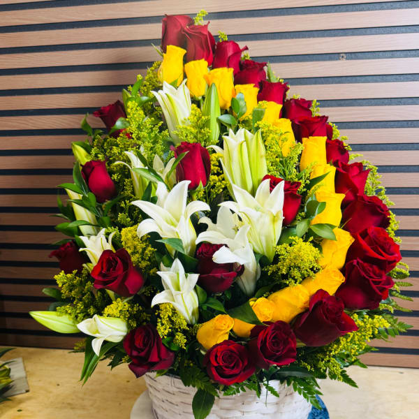 Basket arrangement of red and yellow roses with white lilies