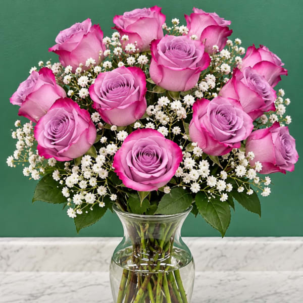 Pink roses and white baby's breath in a clear glass vase