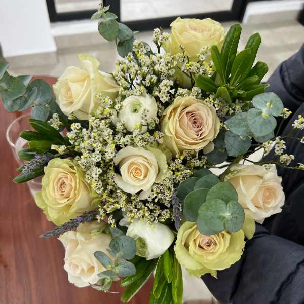 Bouquet of cream roses with small white filler flowers and eucalyptus