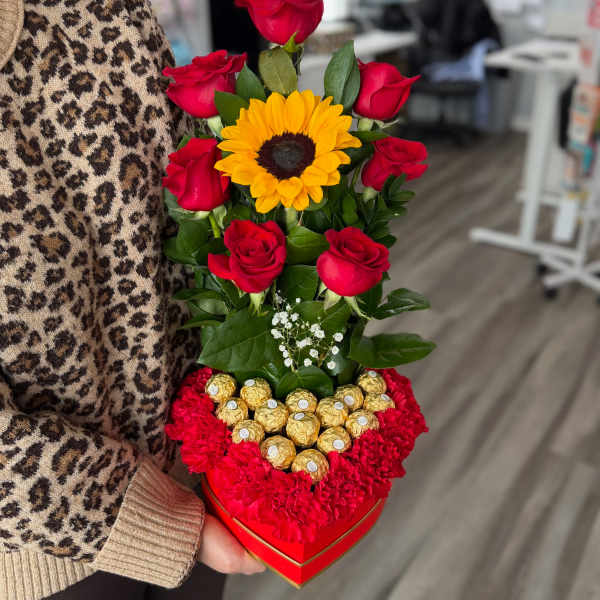 Heart-shaped box with red roses, a sunflower, and chocolates