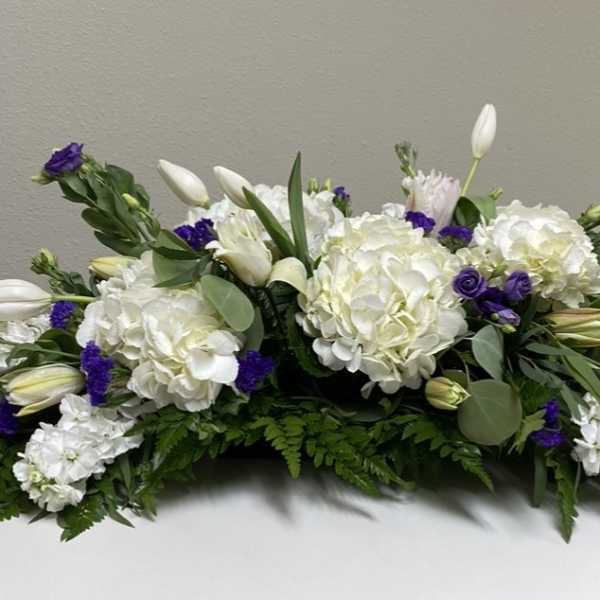 White and purple floral arrangement with hydrangeas and lilies
