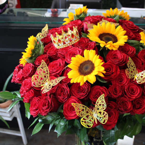 Large bouquet of red roses with yellow sunflowers and butterfly decorations
