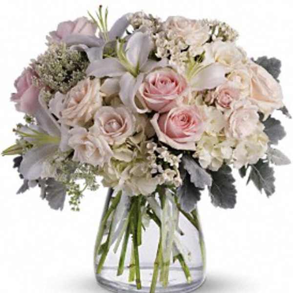 Bouquet of pale pink roses and white lilies in a clear glass vase