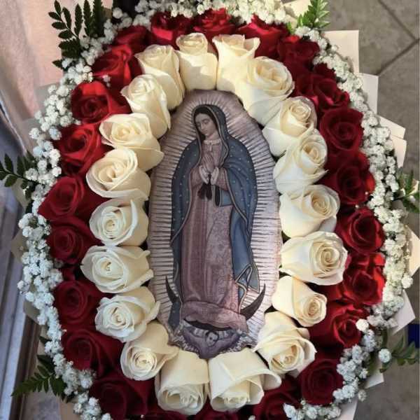Oval bouquet of red and white roses around a religious image