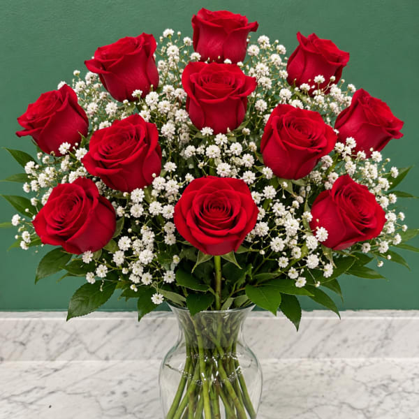 Red roses and white baby's breath in a clear glass vase