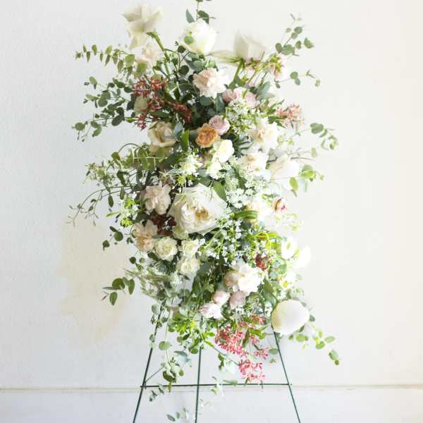 Tall floral arrangement on a metal stand with white and blush blooms