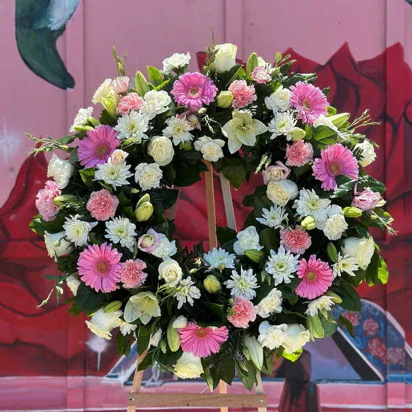 Large floral wreath with pink and white flowers on an easel