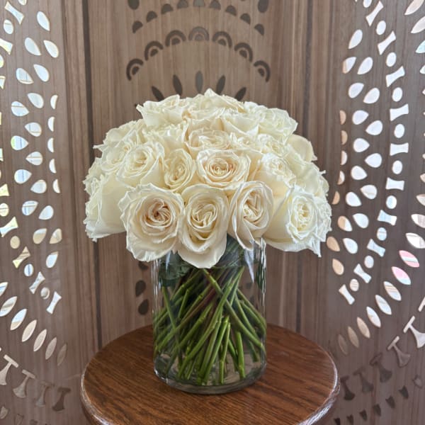White roses arranged in a clear glass vase