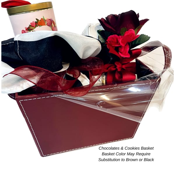 Gift basket with chocolates, cookies, ribbon, and a red flower accent
