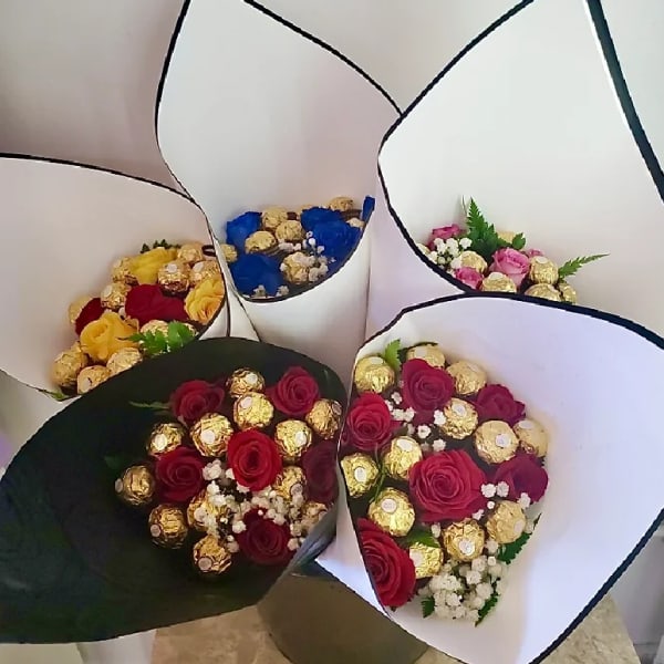 Bouquets of roses and chocolates wrapped in white paper