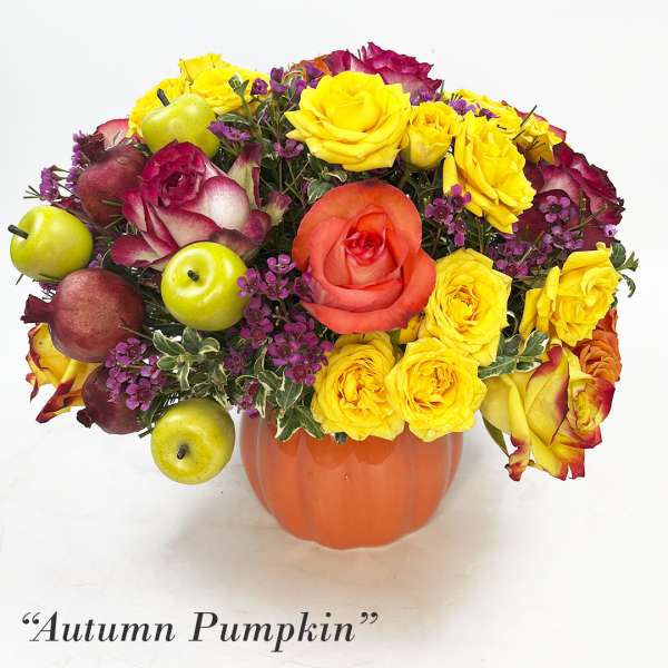Pumpkin-shaped vase with yellow and coral roses and decorative fruit accents