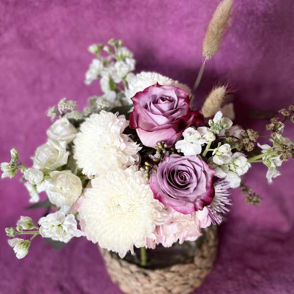 Pink and white rose bouquet in a woven basket