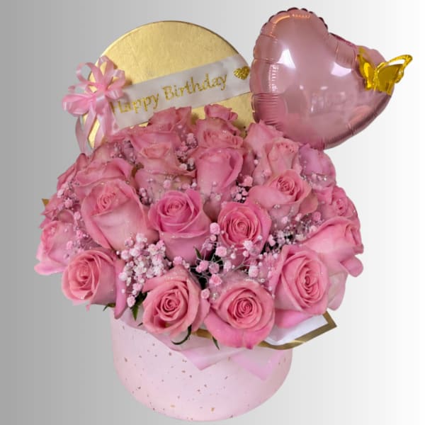Pink rose bouquet in a round gift box with a birthday banner and heart balloon