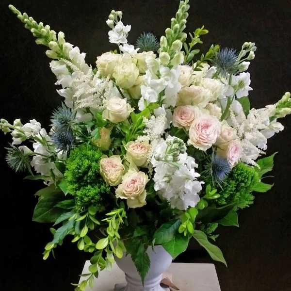 White and blush bouquet in a white pedestal vase