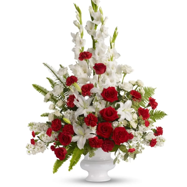 Red roses and white lilies in a white urn vase