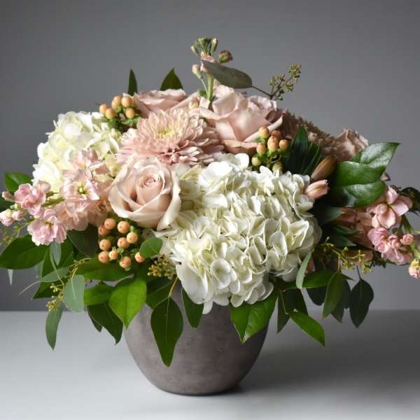 Blush roses and white hydrangeas in a gray vase