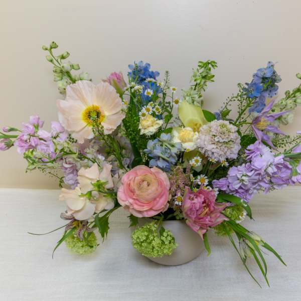 Pastel mixed flower arrangement in a low white vase