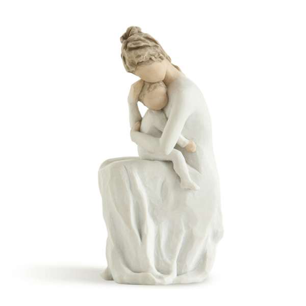 White figurine of a seated woman holding a child