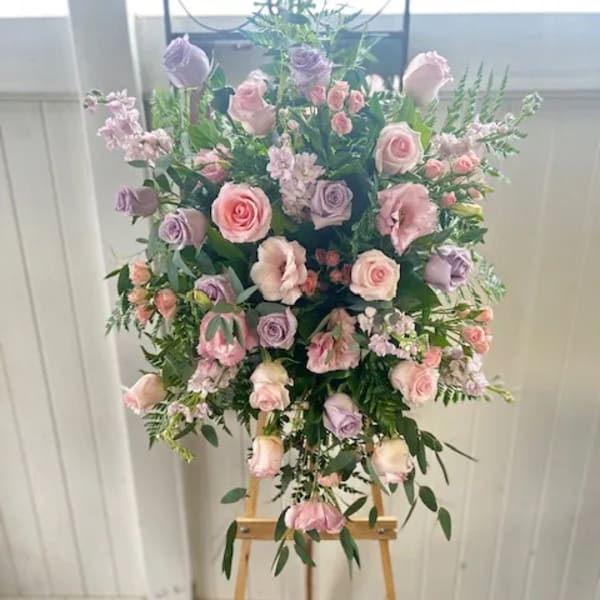 Pastel pink and lavender rose arrangement on a wooden easel
